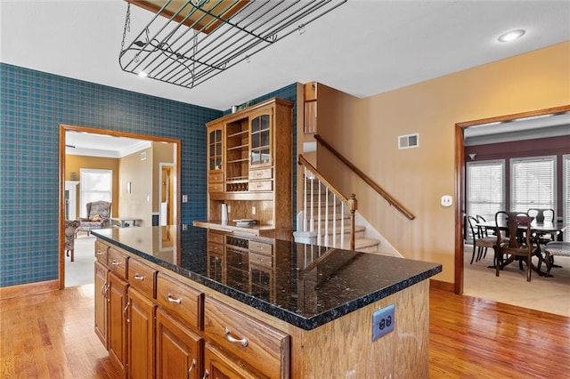 kitchen featuring dark stone countertops, a kitchen island, and light hardwood / wood-style floors