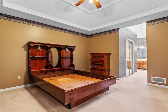 carpeted bedroom featuring connected bathroom, visible vents, ceiling fan, and baseboards