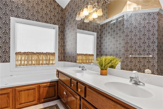 full bathroom featuring a garden tub, double vanity, a sink, and wallpapered walls