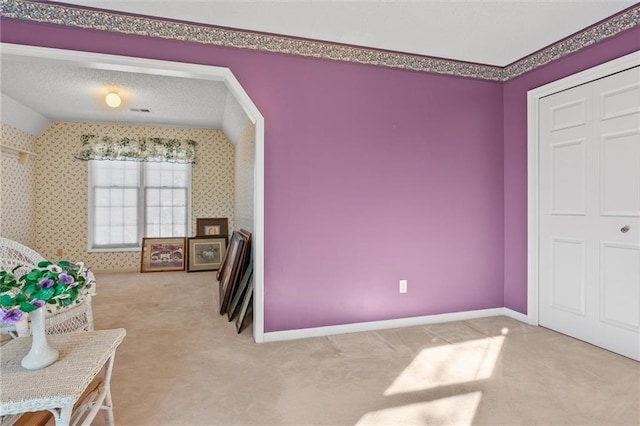 bedroom featuring carpet flooring, a closet, a textured ceiling, and vaulted ceiling