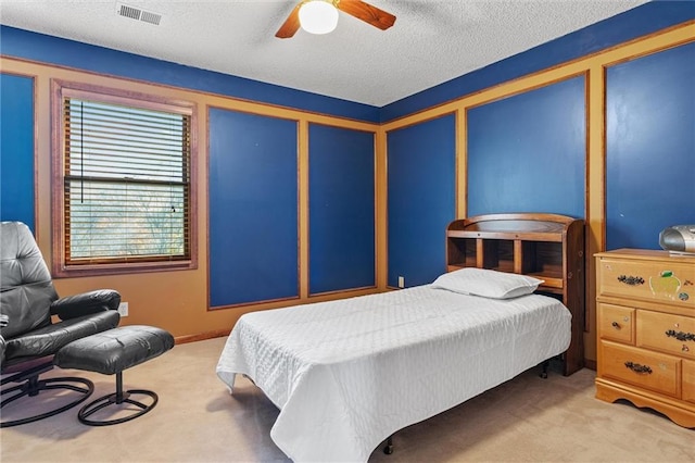 carpeted bedroom with ceiling fan and a textured ceiling