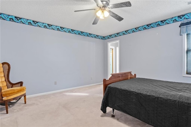 bedroom with a textured ceiling, carpet floors, ceiling fan, and baseboards