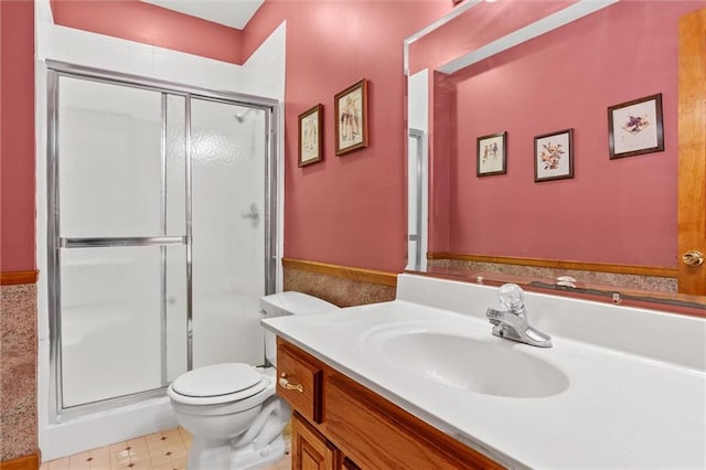 bathroom featuring toilet, a stall shower, and vanity