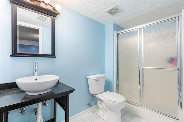 bathroom with a stall shower, visible vents, a sink, and toilet