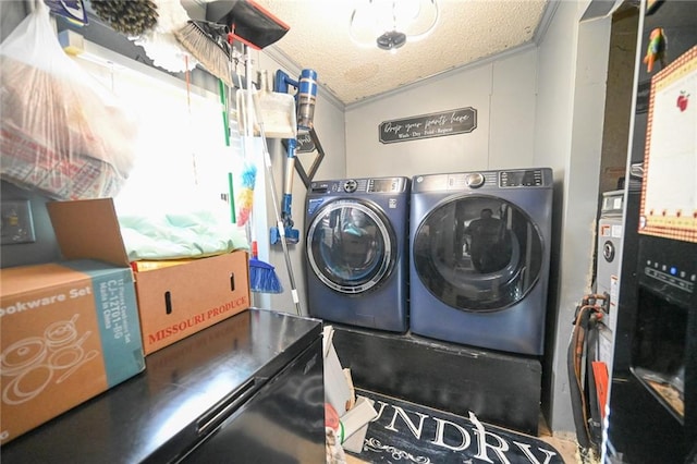 laundry room featuring washing machine and dryer, crown molding, and a textured ceiling