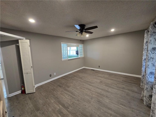 unfurnished bedroom with ceiling fan, dark hardwood / wood-style flooring, and a textured ceiling