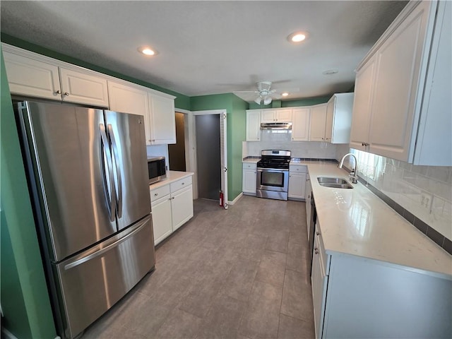 kitchen with backsplash, sink, white cabinetry, and stainless steel appliances