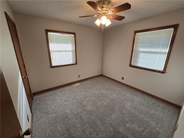 carpeted spare room with ceiling fan and a textured ceiling