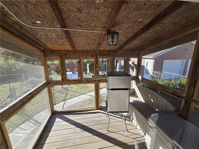 sunroom / solarium featuring beam ceiling