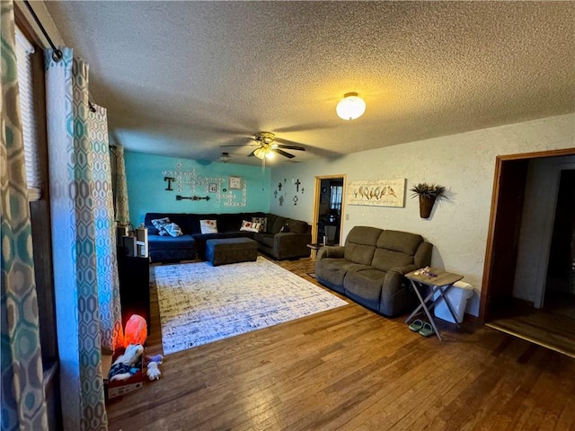 living room with hardwood / wood-style floors, ceiling fan, and a textured ceiling