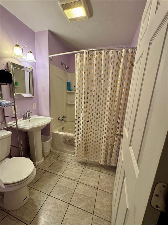 bathroom featuring tile patterned floors, shower / bath combo with shower curtain, and toilet