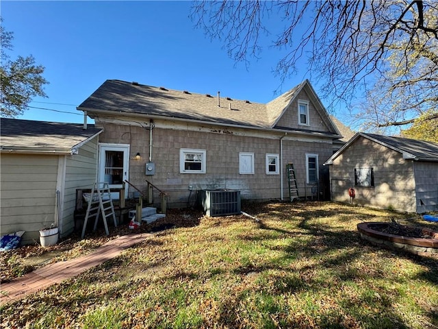 rear view of house featuring a yard and central AC unit