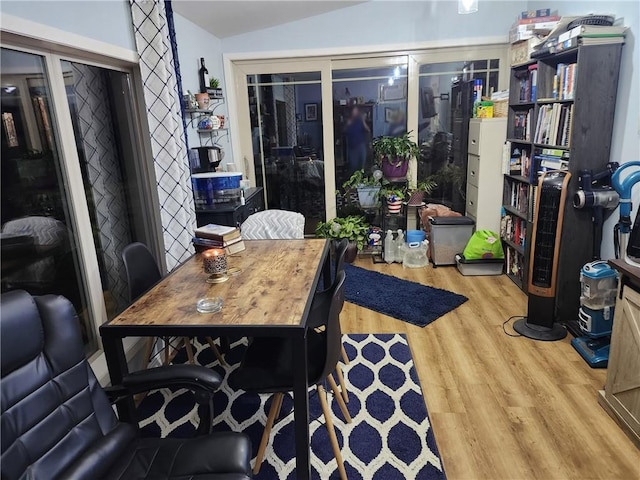 dining room with light hardwood / wood-style floors and lofted ceiling