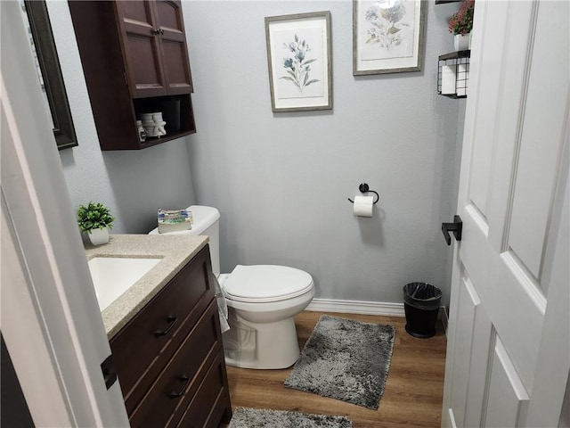 bathroom with hardwood / wood-style floors, vanity, and toilet