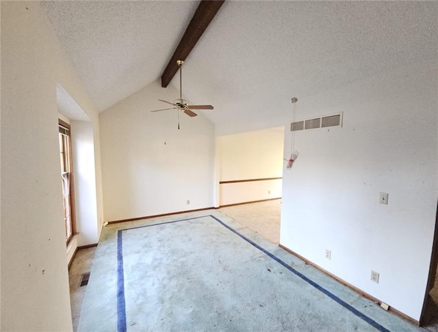 spare room featuring vaulted ceiling with beams, ceiling fan, a textured ceiling, and light carpet