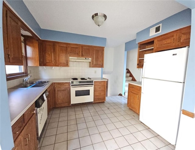 kitchen featuring light tile patterned flooring, sink, white appliances, and backsplash