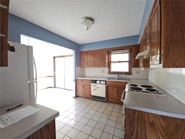 kitchen featuring backsplash, a textured ceiling, white appliances, sink, and light tile patterned flooring