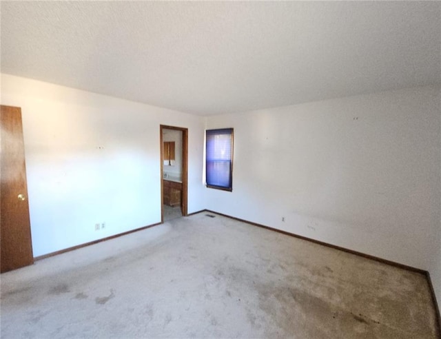 unfurnished room featuring light carpet and a textured ceiling