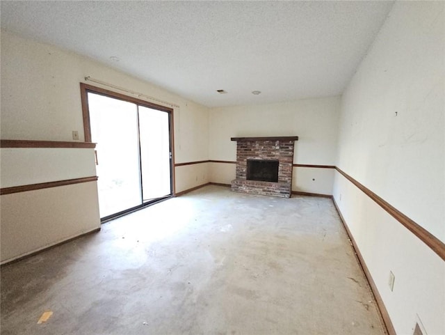 unfurnished living room with a fireplace and a textured ceiling