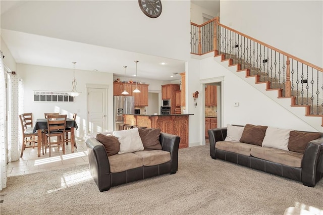 carpeted living room featuring a towering ceiling