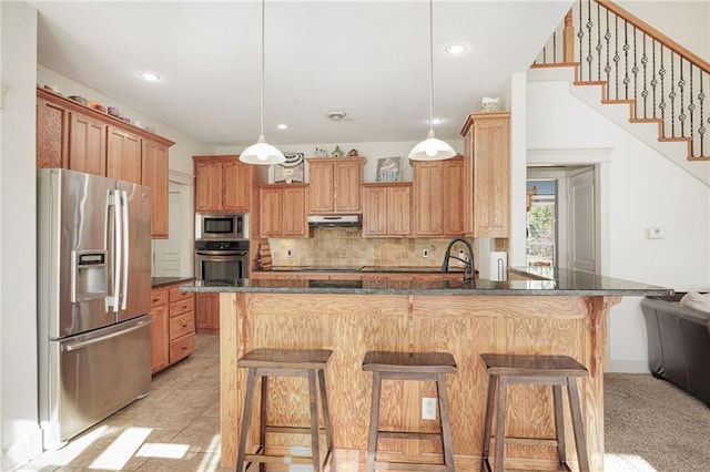 kitchen with kitchen peninsula, decorative light fixtures, a breakfast bar, light tile patterned flooring, and appliances with stainless steel finishes