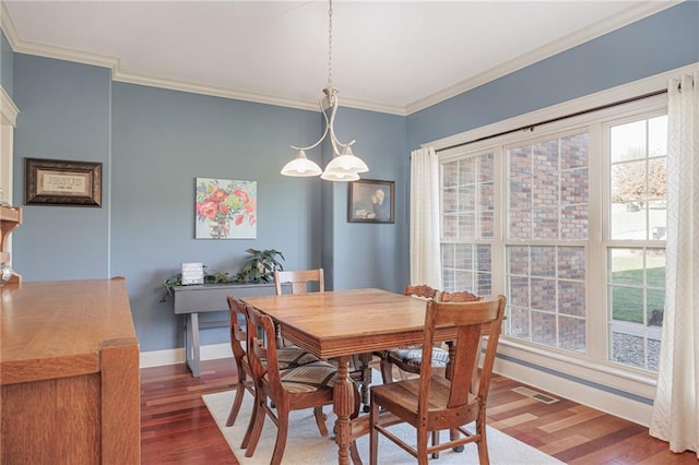 dining area with dark hardwood / wood-style floors and crown molding