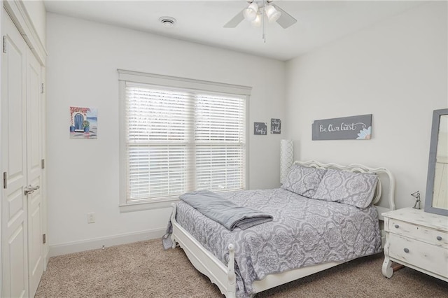 bedroom featuring ceiling fan, a closet, and light colored carpet