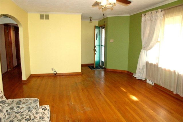 spare room with a wealth of natural light, crown molding, hardwood / wood-style floors, and ceiling fan