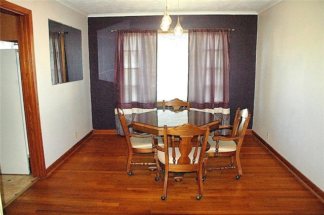 dining space featuring dark hardwood / wood-style flooring and ornamental molding