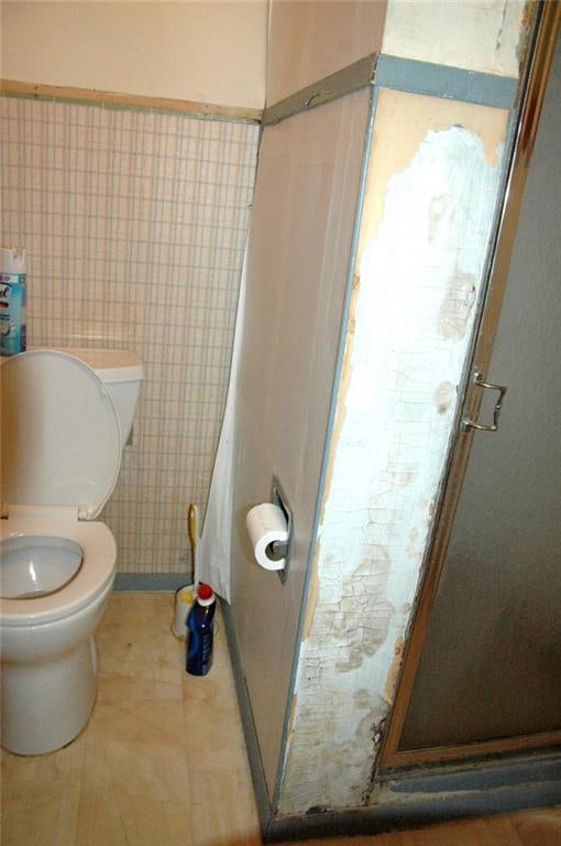 bathroom with toilet and a shower with shower door