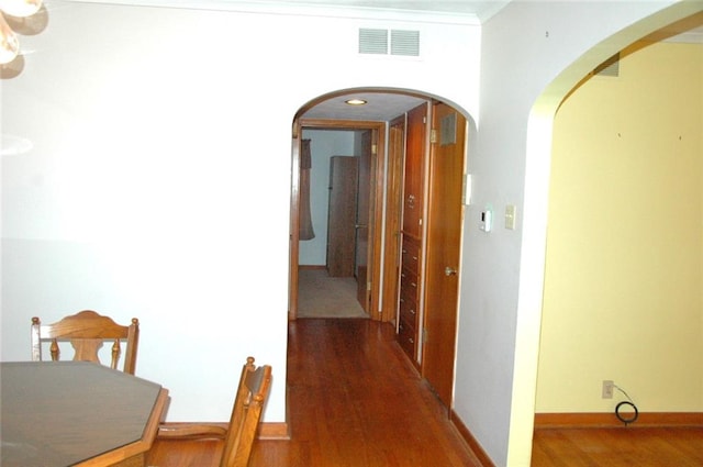 hallway with crown molding and dark hardwood / wood-style flooring