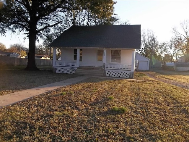 view of front facade with an outbuilding, a porch, and a garage