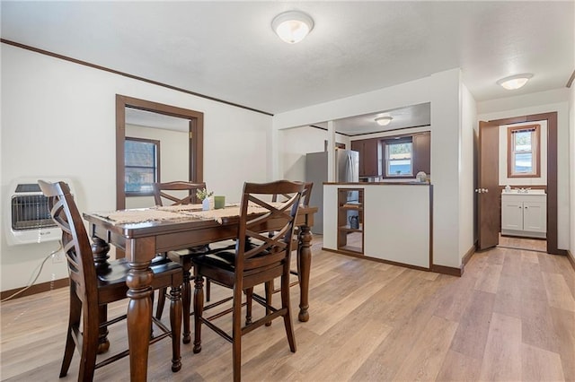 dining space with light hardwood / wood-style floors, sink, and heating unit