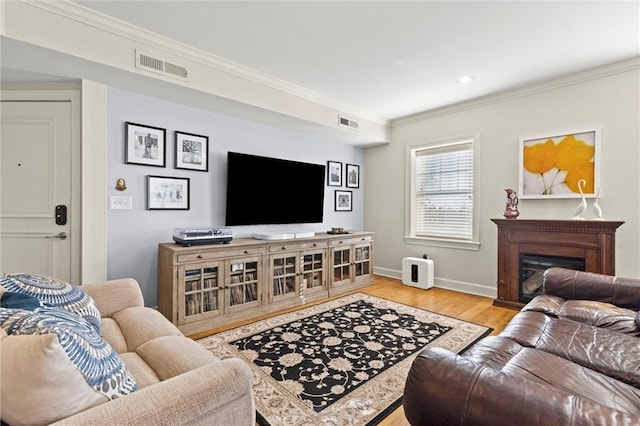 living room featuring light hardwood / wood-style flooring and ornamental molding