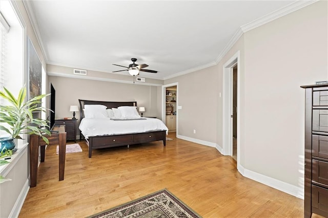 bedroom featuring ceiling fan, ornamental molding, and light hardwood / wood-style flooring