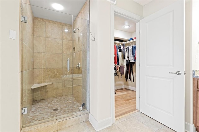 bathroom with a shower with door and tile patterned floors