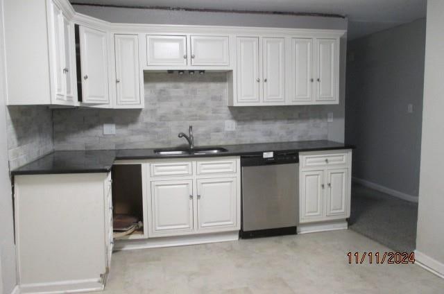 kitchen featuring white cabinets, tasteful backsplash, stainless steel dishwasher, and sink