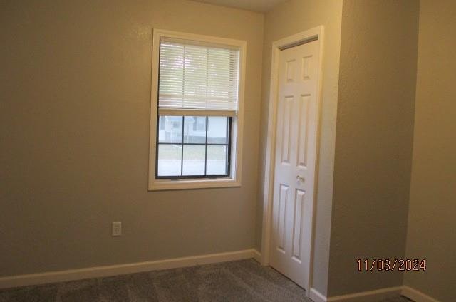 empty room featuring dark colored carpet