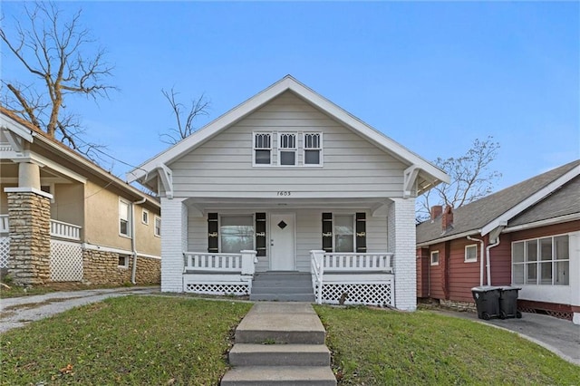 bungalow-style house with covered porch and a front yard