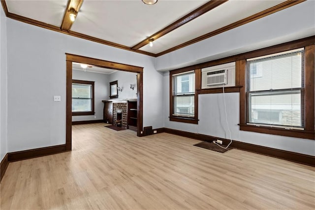 spare room with crown molding, light hardwood / wood-style flooring, and a brick fireplace