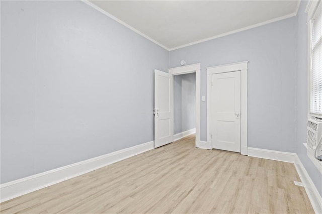 spare room with light hardwood / wood-style floors, ornamental molding, and a healthy amount of sunlight