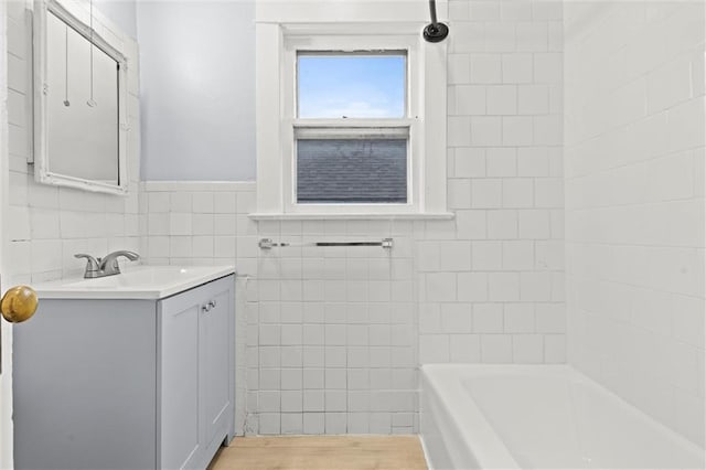 bathroom featuring hardwood / wood-style floors, vanity, and tile walls