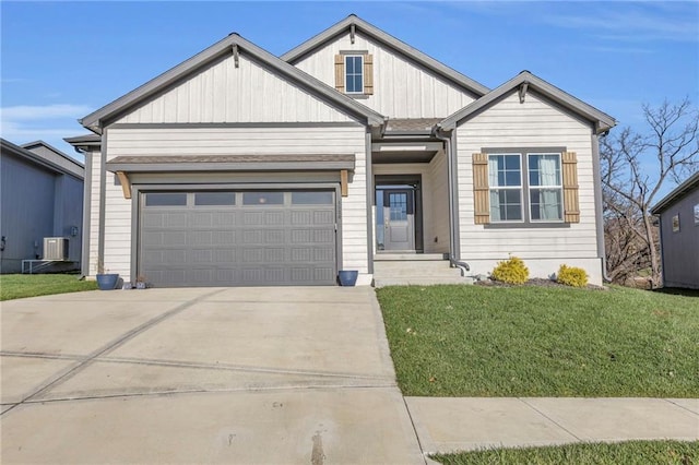 view of front of house with a front yard, a garage, and central AC unit