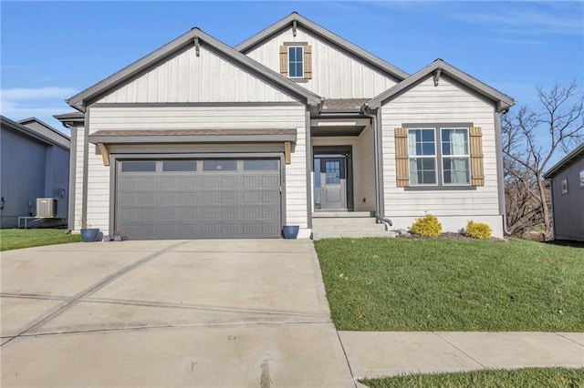 4520 NW 49th Ct, Riverside, MO 64150 - view of front of home with a garage, driveway, a front yard, board and batten siding, and central AC unit