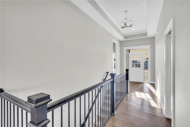 hallway with a notable chandelier and hardwood / wood-style flooring