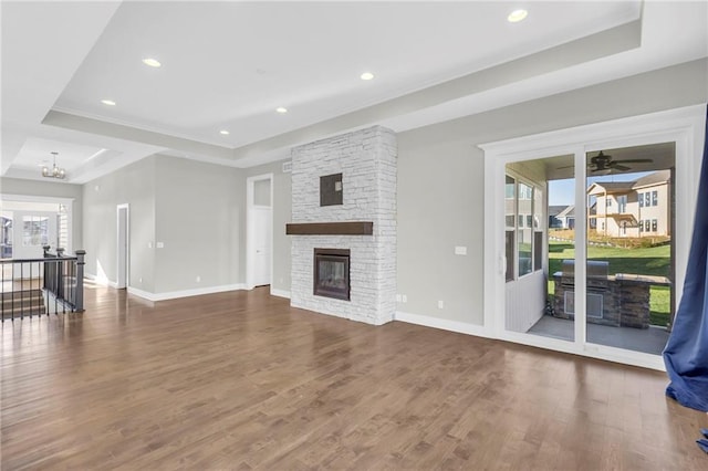 unfurnished living room with dark wood-type flooring, a wealth of natural light, and a tray ceiling