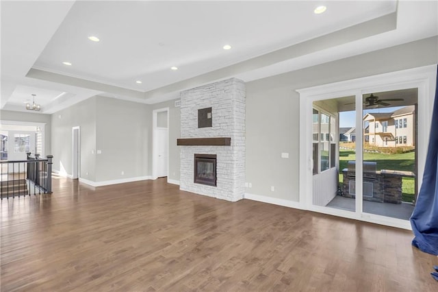 4520 NW 49th Ct, Riverside, MO 64150 - unfurnished living room featuring a tray ceiling, dark wood-style floors, baseboards, a fireplace, and recessed lighting