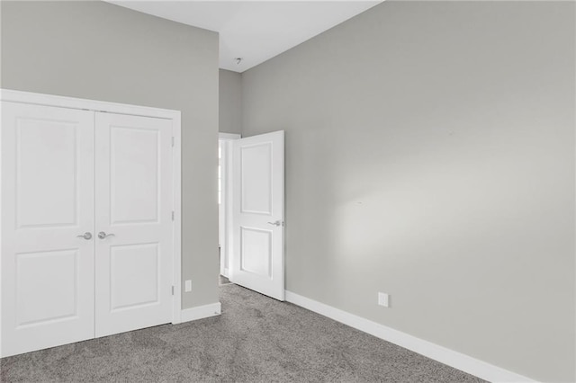 unfurnished bedroom featuring a closet and light colored carpet