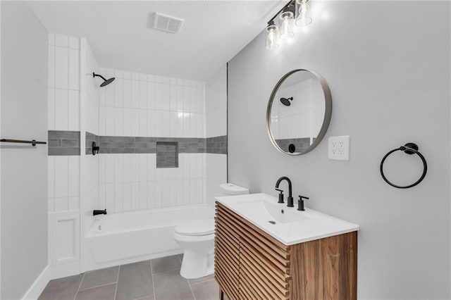 full bathroom featuring tile patterned flooring, tiled shower / bath combo, toilet, and vanity