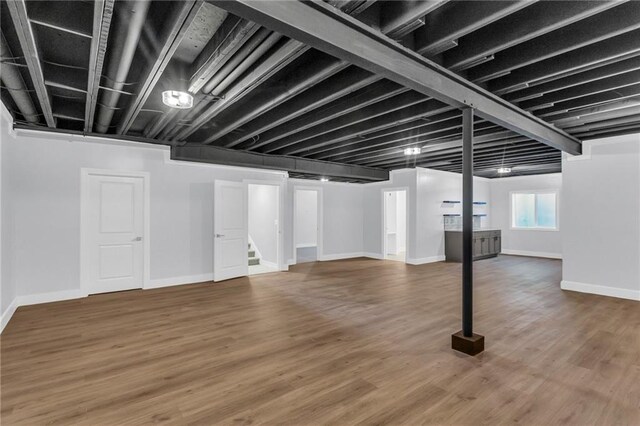 4520 NW 49th Ct, Riverside, MO 64150 - below grade area featuring stairway, baseboards, and wood finished floors